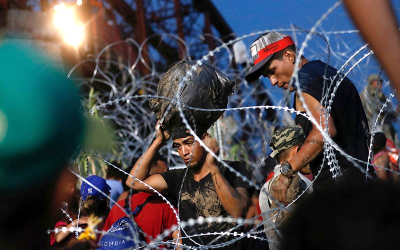 Asylum-seekers wait on the banks of the Rio Grande in Piedras Negras, Mexico, Sept. 26, 2023, after crossing during their journey through Mexico to Eagle Pass, Texas. U.S President Joe Biden June 4 signed an executive order temporarily shutting down asylum requests.